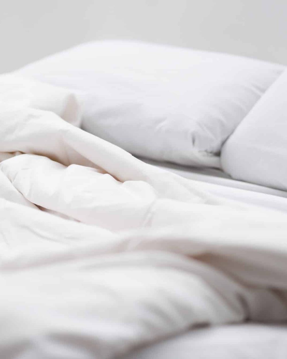 selective focus of bed with white pillows and blanket